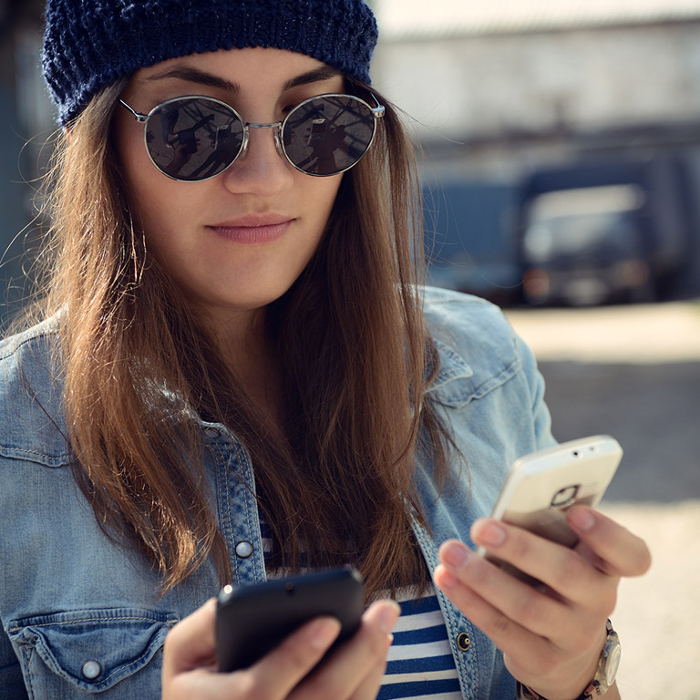 mujer transfiriendo una llamada de un celular a otro